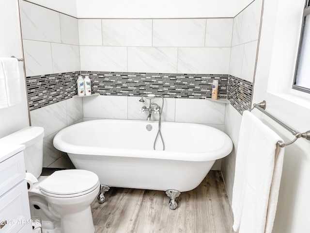 bathroom featuring tile walls, a tub to relax in, wood-type flooring, and toilet