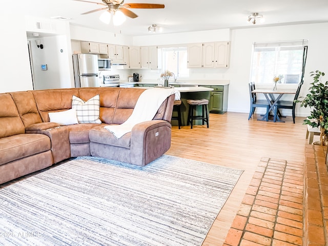 living room with ceiling fan and light wood-type flooring