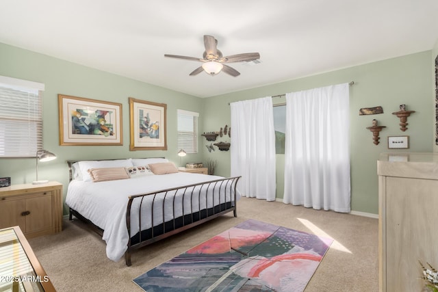 bedroom featuring light carpet, baseboards, and a ceiling fan