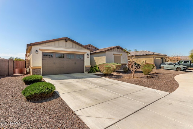 view of front of home with a gate, driveway, stucco siding, stone siding, and a garage