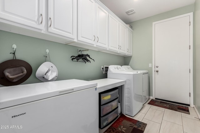 laundry area with visible vents, cabinet space, and washing machine and clothes dryer