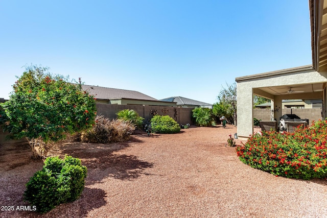 view of yard featuring a patio area, a ceiling fan, and a fenced backyard