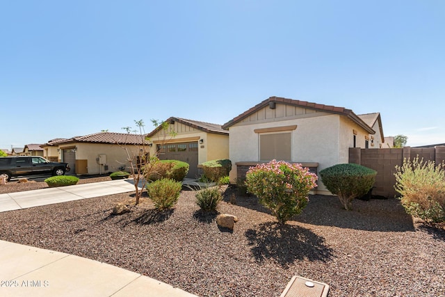 view of front facade featuring stucco siding, driveway, an attached garage, and fence