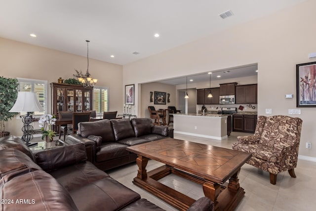 living room featuring light tile patterned floors and an inviting chandelier