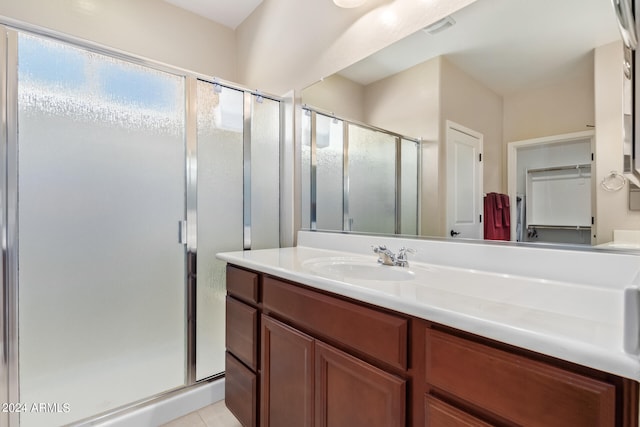 bathroom with vanity, walk in shower, and tile patterned flooring