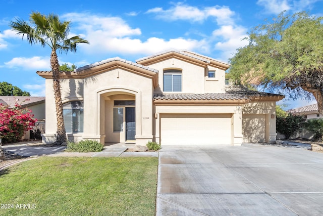 mediterranean / spanish home with a front lawn and a garage