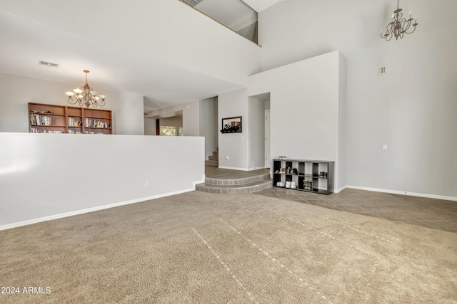 unfurnished living room featuring carpet flooring, a high ceiling, and a chandelier