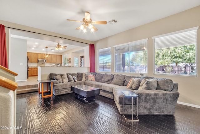 living room featuring ceiling fan and dark hardwood / wood-style flooring