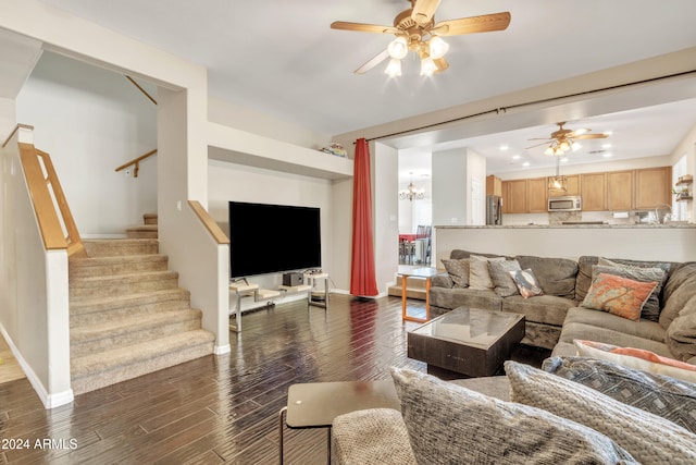 living room with ceiling fan with notable chandelier and dark wood-type flooring