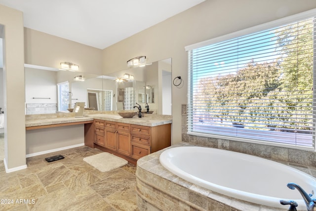 bathroom featuring vanity and tiled tub