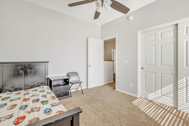bedroom with ceiling fan, light colored carpet, and a closet
