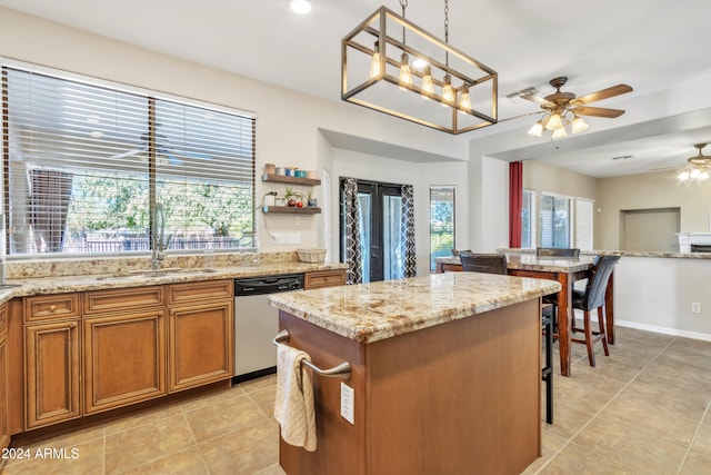 kitchen with dishwasher, ceiling fan with notable chandelier, light tile patterned floors, decorative light fixtures, and a kitchen island
