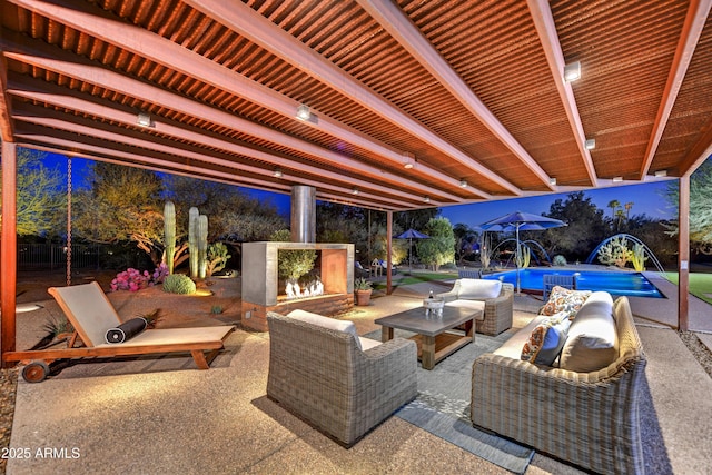 view of patio / terrace with an outdoor living space with a fireplace, an outdoor pool, and fence private yard