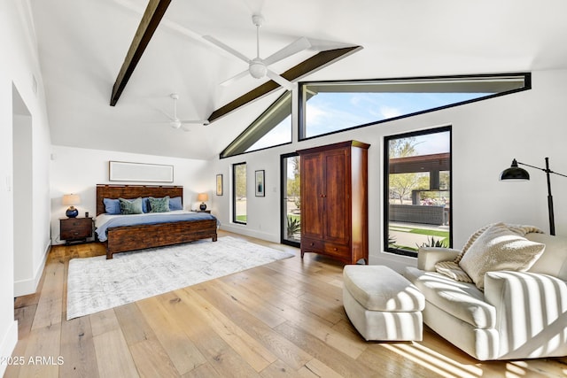 bedroom featuring a ceiling fan, baseboards, lofted ceiling with beams, access to exterior, and light wood-type flooring