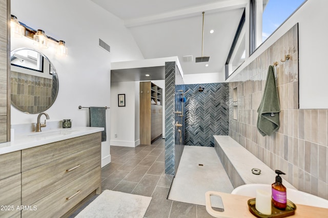 bathroom featuring visible vents, plenty of natural light, a walk in shower, and vanity