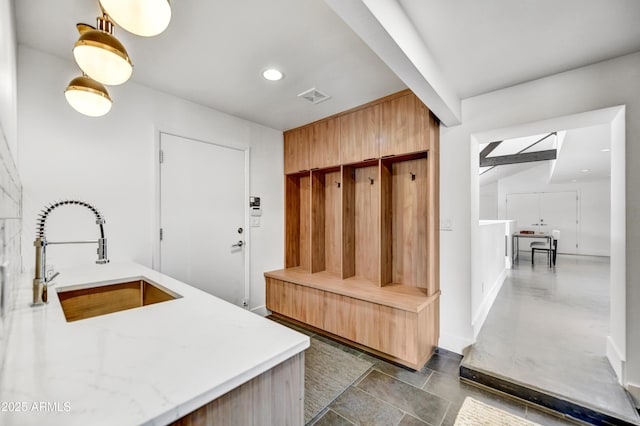 mudroom featuring visible vents, recessed lighting, and a sink