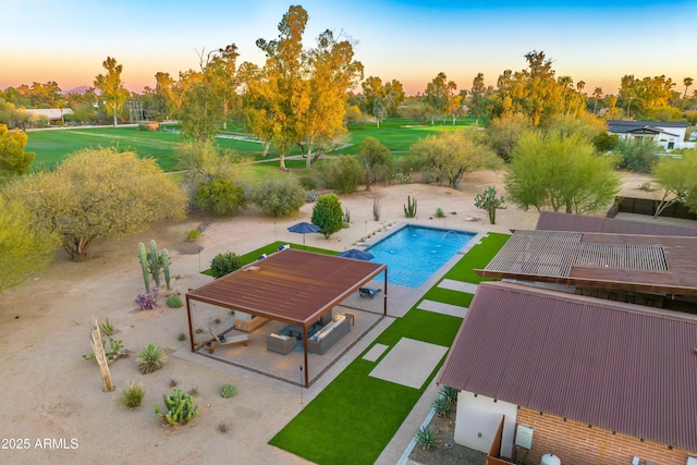 pool at dusk featuring a patio and an outdoor pool