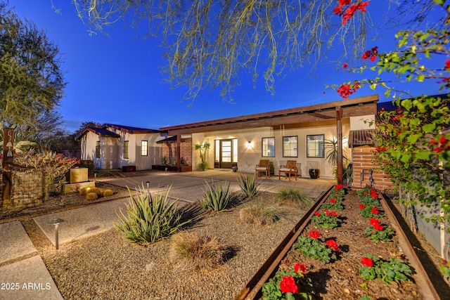 rear view of house featuring stucco siding and a patio