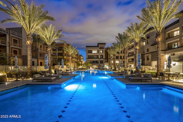 pool at dusk featuring a patio