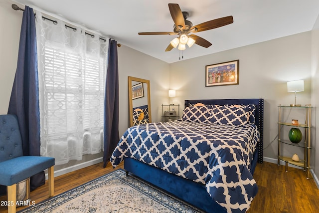 bedroom with ceiling fan, baseboards, and wood finished floors