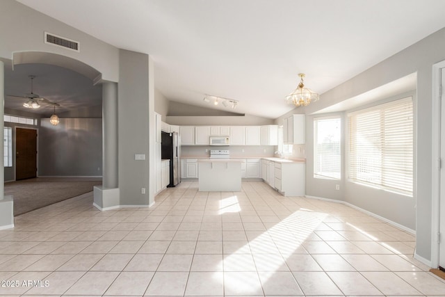 21 E Irvine Rd, Phoenix, AZ 85086 - kitchen featuring white microwave, stainless steel fridge with ice dispenser, lofted ceiling, light tile patterned floors, and healthy amount of natural light