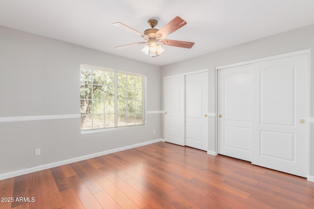 21 E Irvine Rd, Phoenix, AZ 85086 - unfurnished bedroom with two closets, wood finished floors, and ceiling fan