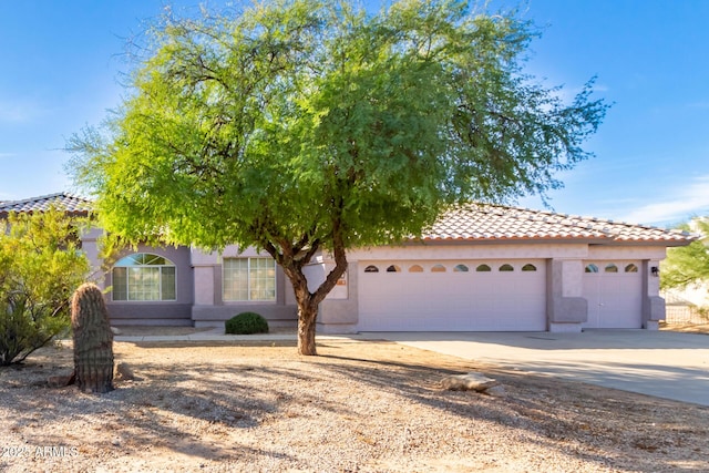 21 E Irvine Rd, Phoenix, AZ 85086 - view of front of home featuring an attached garage, driveway, a tiled roof, and stucco siding