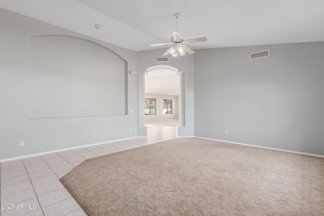 21 E Irvine Rd, Phoenix, AZ 85086 - spare room featuring ceiling fan, light tile patterned flooring, arched walkways, and light carpet