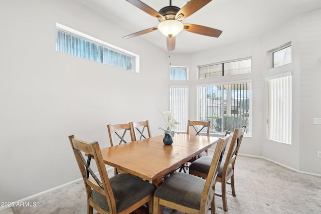 dining room with ceiling fan and light carpet