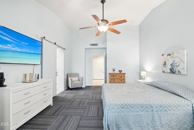 bedroom with a barn door, lofted ceiling, and ceiling fan