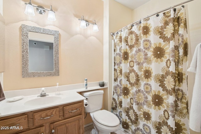 bathroom featuring vanity, walk in shower, and toilet