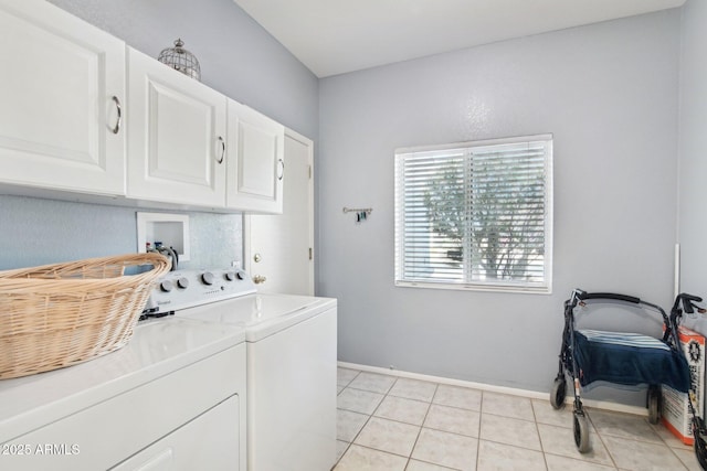 washroom featuring cabinets, washing machine and clothes dryer, and light tile patterned flooring