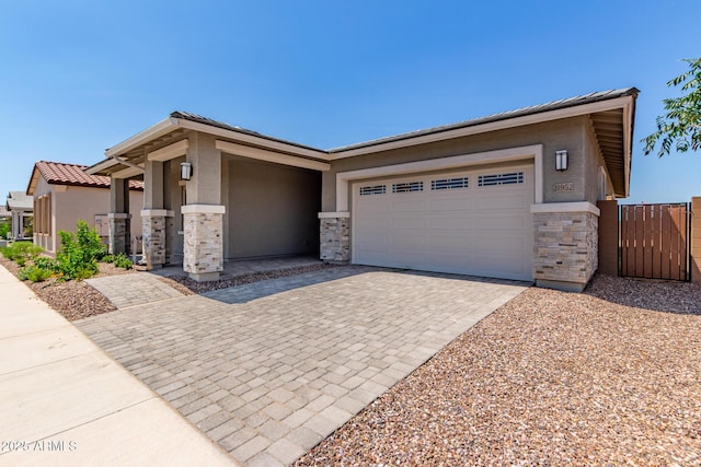 21952 E Saddle Ct E, Queen Creek, AZ 85142 - view of front of home with stone siding, stucco siding, driveway, an attached garage, and a gate