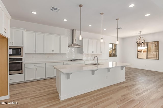 21952 E Saddle Ct E, Queen Creek, AZ 85142 - kitchen with oven, wall chimney exhaust hood, a sink, light countertops, and light wood finished floors
