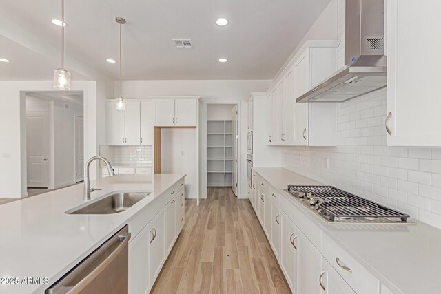 21952 E Saddle Ct E, Queen Creek, AZ 85142 - kitchen with wall chimney exhaust hood, stainless steel appliances, a sink, white cabinets, and recessed lighting