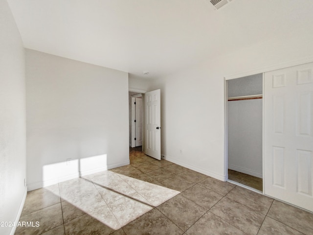 unfurnished bedroom featuring a closet and light tile patterned floors