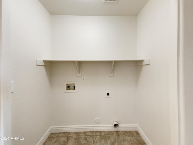 clothes washing area featuring electric dryer hookup, hookup for a washing machine, light tile patterned floors, and gas dryer hookup