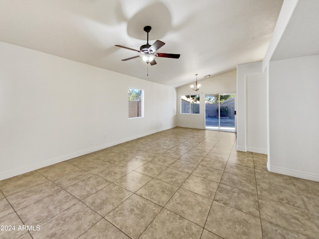 tiled spare room with ceiling fan with notable chandelier and vaulted ceiling