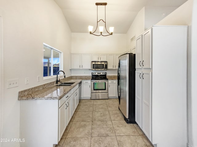 kitchen featuring pendant lighting, sink, white cabinetry, stainless steel appliances, and light stone countertops