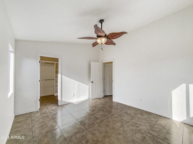 tiled spare room with ceiling fan and vaulted ceiling