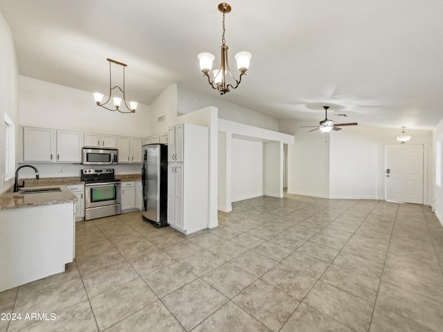 kitchen featuring light stone counters, hanging light fixtures, sink, white cabinetry, and stainless steel appliances