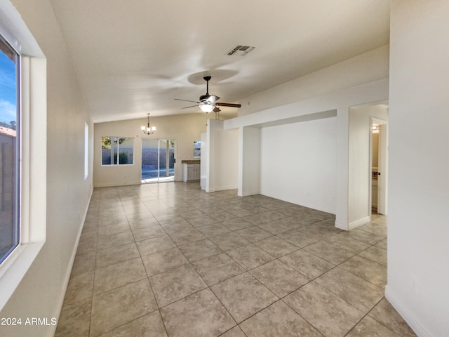 unfurnished living room with ceiling fan with notable chandelier and light tile patterned flooring