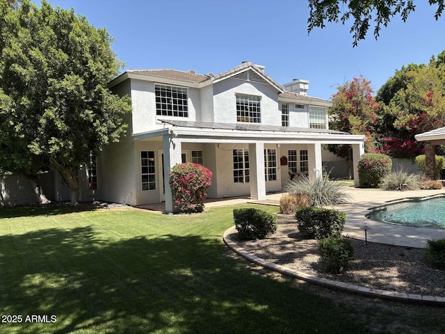 rear view of house featuring a yard, a patio area, fence, stucco siding, and an outdoor pool