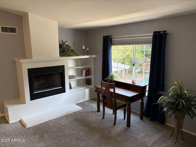 carpeted dining space featuring visible vents, baseboards, and a fireplace