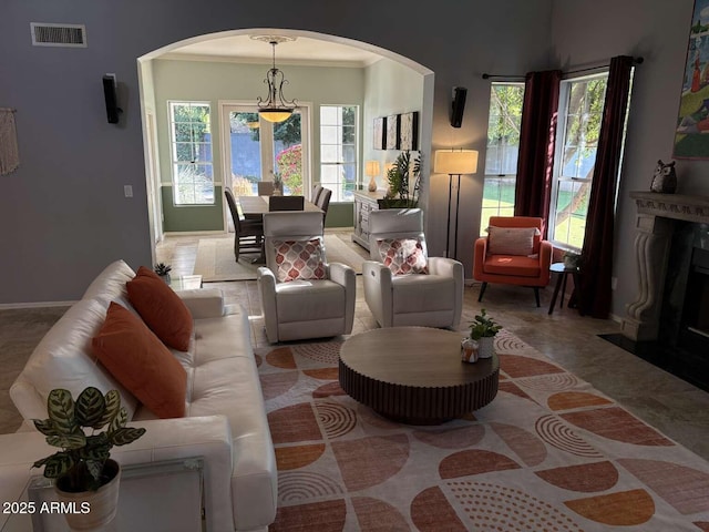 living area with visible vents, arched walkways, and plenty of natural light