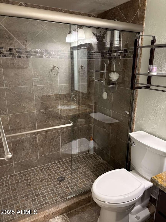 full bath featuring toilet, a shower stall, and a textured wall