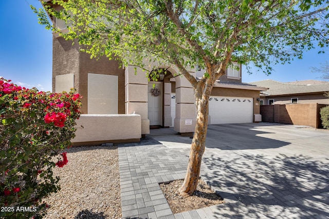 view of front of property featuring stucco siding, concrete driveway, and a garage