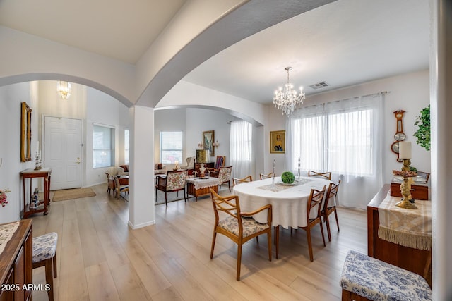 dining area featuring a chandelier, visible vents, light wood-style flooring, and baseboards