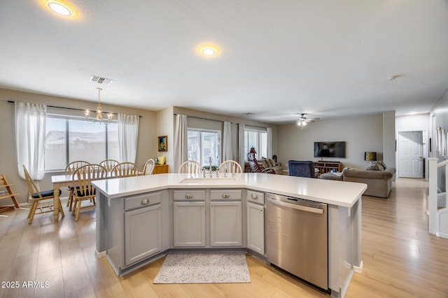 kitchen with dishwasher, light countertops, open floor plan, and visible vents