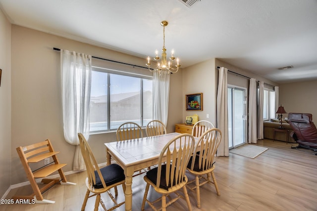 dining space featuring a notable chandelier, visible vents, light wood-style flooring, and baseboards